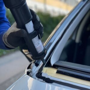 Close-up of a technician repairing a car windshield in a Copenhagen workshop.