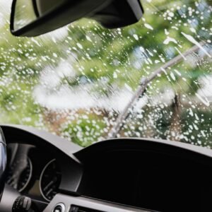 Interior view of a car with soapy windshield during cleaning. Clear dashboard visible.